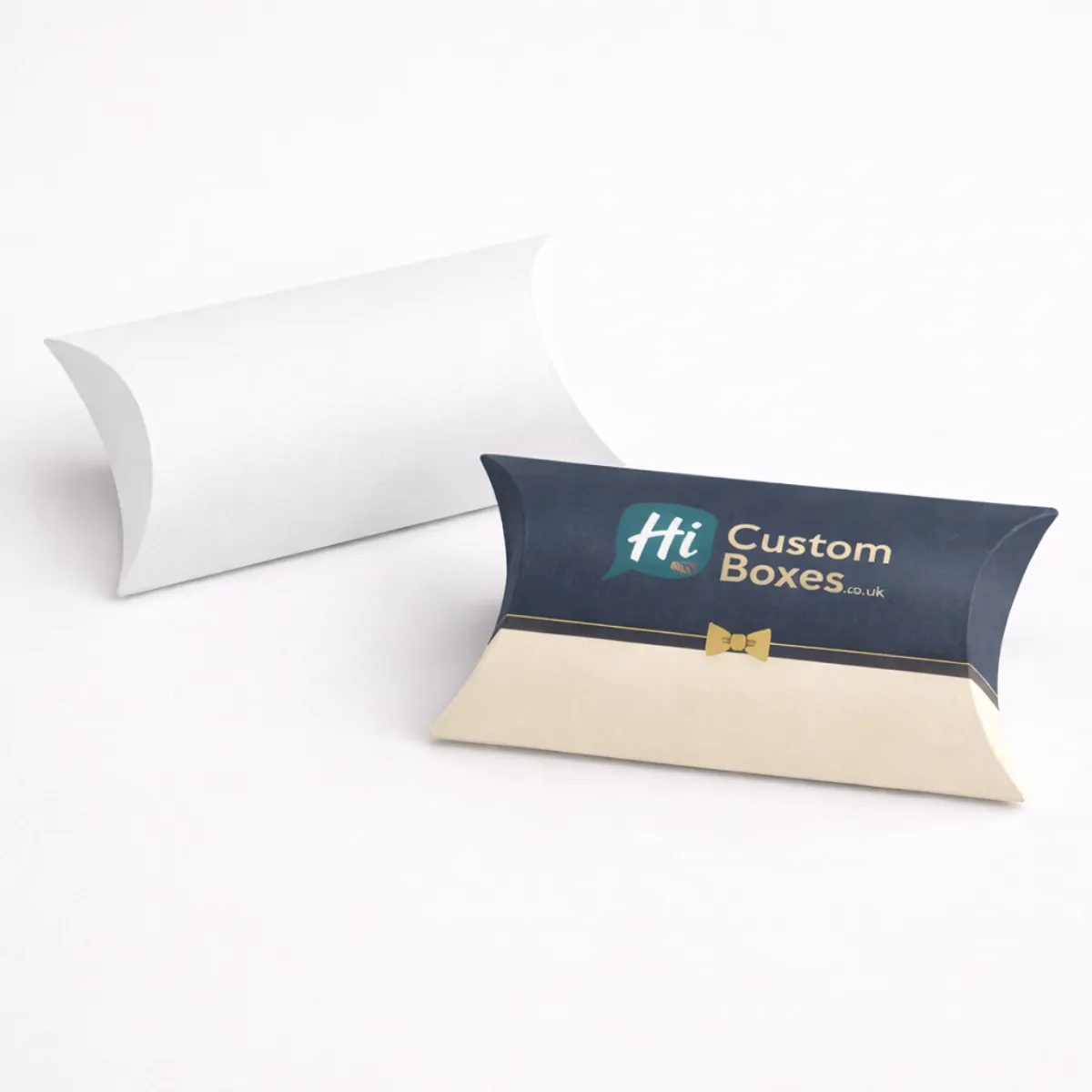 Two elegant pillow-shaped packaging boxes- one plain white and one branded with a navy finish- class=